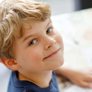 Boy smiling at his school desk