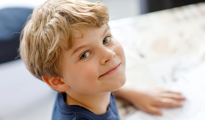 Boy smiling at his school desk